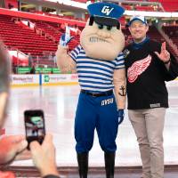 An alumnus posing with Louie the Laker at the Detroit Red Wings GVSU Night